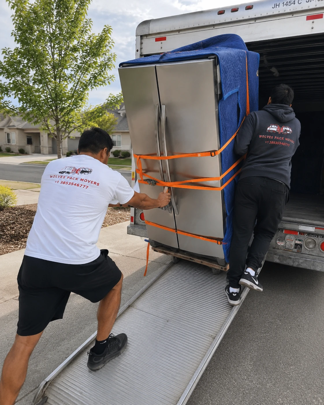 Heavy appliance movers in Utah loading a refrigerator onto a truck