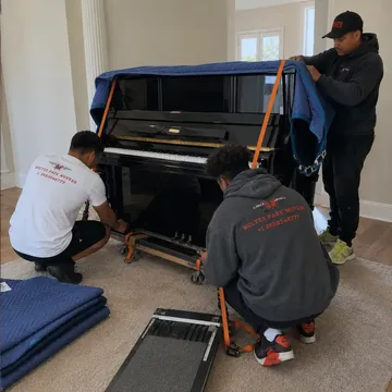 Professional piano movers blanket-wrapping a piano in Oregon