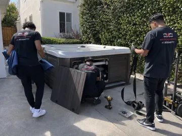 Hot tub movers Utah carrying a wrapped spa on dollies