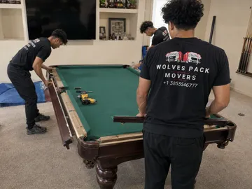Wolves Pack Movers disassembling a slate pool table in Utah