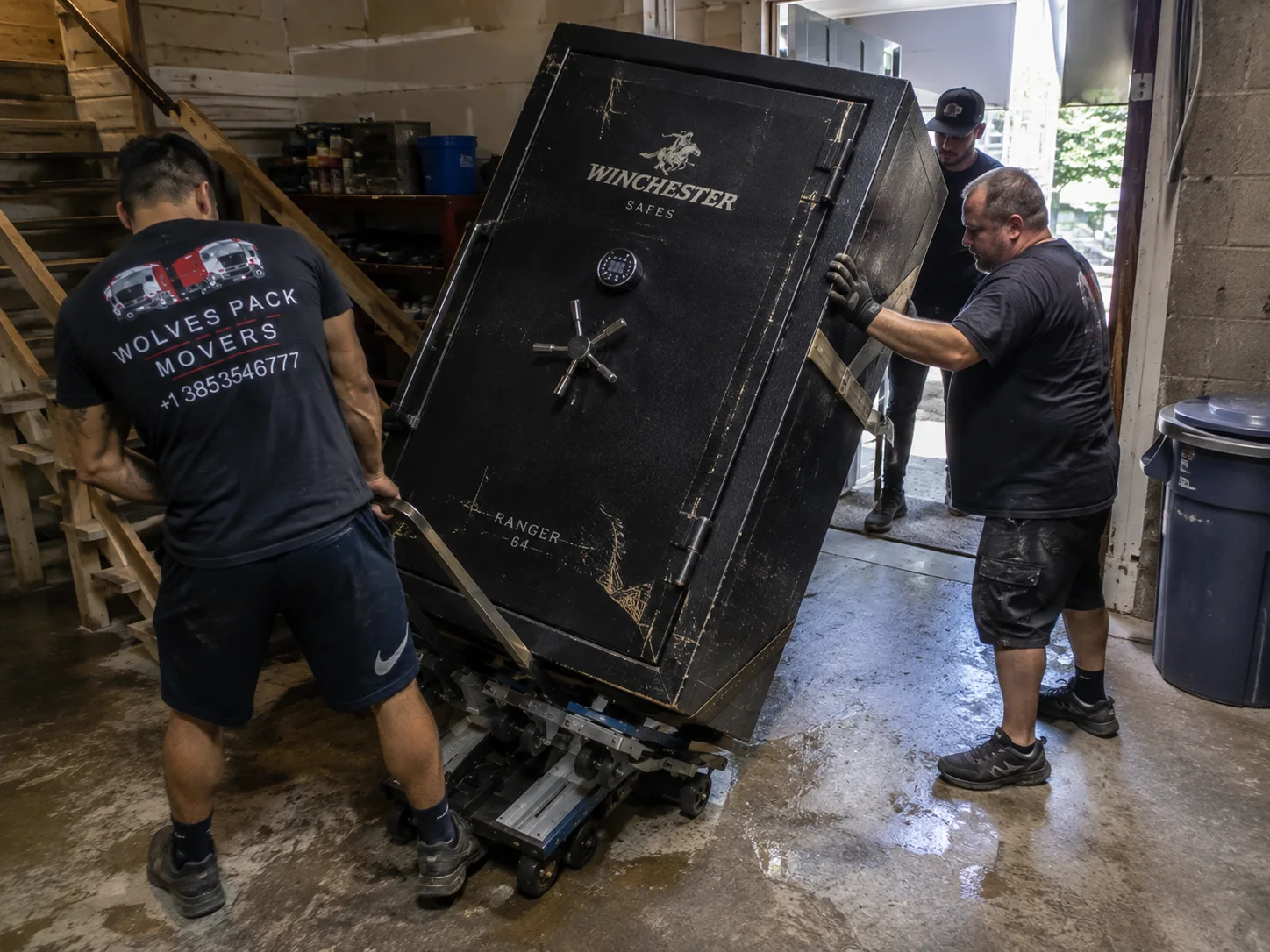 Gun safe moving crew using dollies and straps