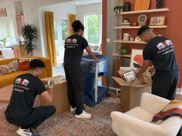 Professional packers wrapping office items